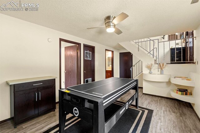4303 W Eastcrest Cir, Colorado Springs, CO 80916 - rec room featuring a ceiling fan, light wood-style flooring, a textured ceiling, and baseboards