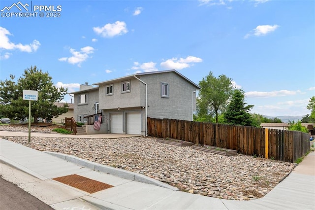 4303 W Eastcrest Cir, Colorado Springs, CO 80916 - view of front of property featuring an attached garage, stucco siding, a chimney, and driveway