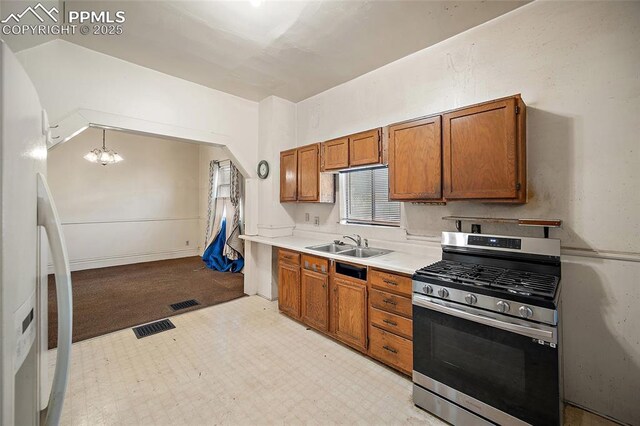 117 S Limit St, Colorado Springs, CO 80905 - kitchen featuring gas range, freestanding refrigerator, a sink, and brown cabinetry