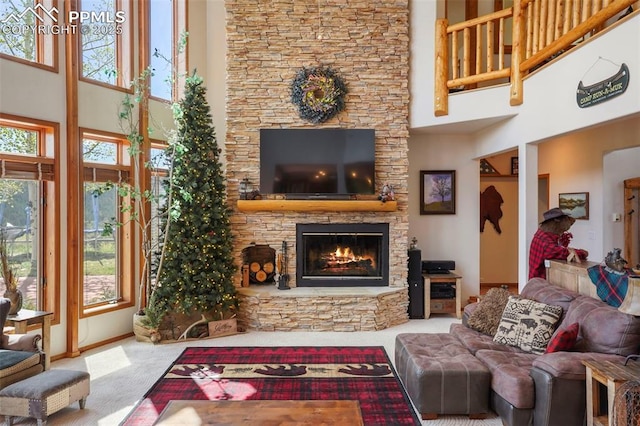215 Morning Sun Dr, Woodland Park, CO 80863 - carpeted living room with a high ceiling, a stone fireplace, and plenty of natural light