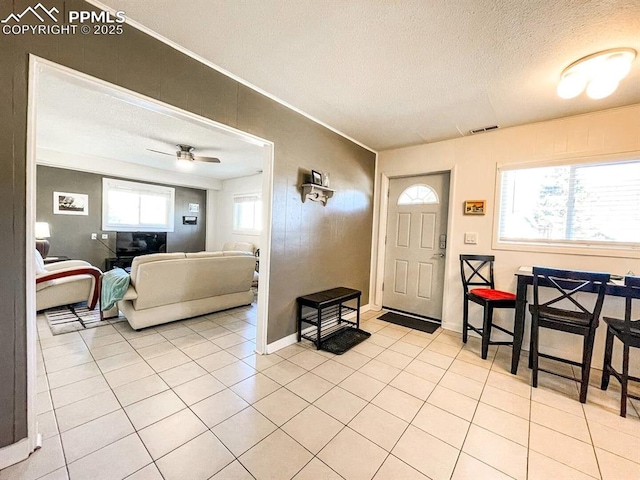 418 N Baldwin St, Woodland Park, CO 80863 - entryway featuring a textured ceiling, light tile patterned floors, ceiling fan, ornamental molding, and baseboards