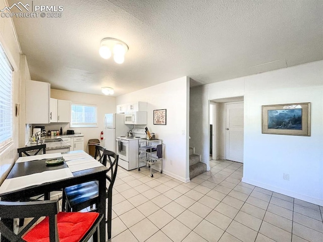 418 N Baldwin St, Woodland Park, CO 80863 - dining area featuring light tile patterned flooring, baseboards, a textured ceiling, and stairs