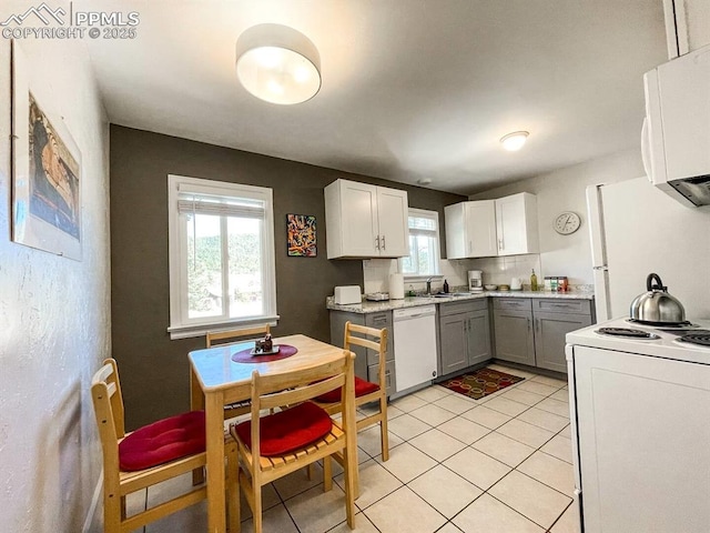 418 N Baldwin St, Woodland Park, CO 80863 - kitchen with white appliances, a sink, light tile patterned flooring, light countertops, and white cabinets
