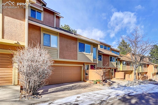 4120 Autumn Heights Dr Unit B, Colorado Springs, CO 80906 - townhome / multi-family property with stucco siding, a garage, a residential view, and driveway