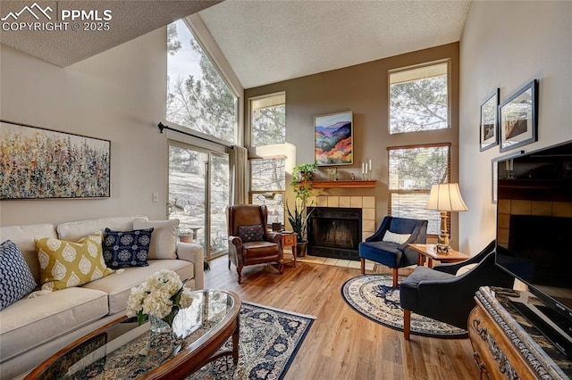 4120 Autumn Heights Dr Unit B, Colorado Springs, CO 80906 - living area featuring a fireplace, high vaulted ceiling, a textured ceiling, and wood finished floors