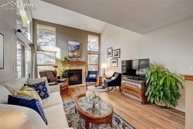 4120 Autumn Heights Dr Unit B, Colorado Springs, CO 80906 - living area with a tile fireplace, wood finished floors, lofted ceiling, and a textured ceiling