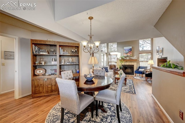 4120 Autumn Heights Dr Unit B, Colorado Springs, CO 80906 - dining area featuring light wood-style floors, a tile fireplace, and a chandelier