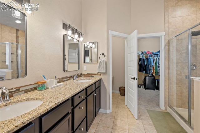 6374 Tramore Way, Colorado Springs, CO 80923 - bathroom featuring a stall shower, double vanity, tile patterned flooring, and a walk in closet