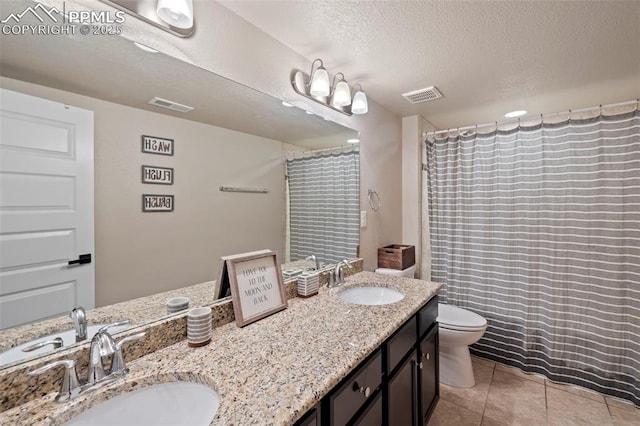 6374 Tramore Way, Colorado Springs, CO 80923 - bathroom with double vanity, tile patterned flooring, a textured ceiling, and a shower with shower curtain