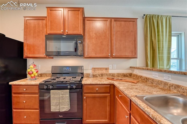 6676 Liberator Trl, Colorado Springs, CO 80925 - kitchen featuring black appliances, a sink, and brown cabinets