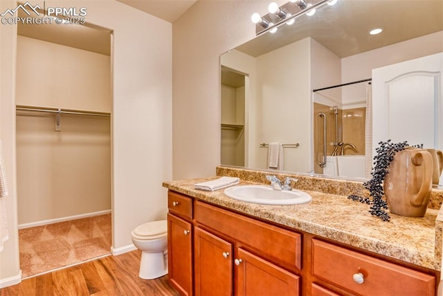 6676 Liberator Trl, Colorado Springs, CO 80925 - full bath with a shower, vanity, toilet, wood finished floors, and a walk in closet