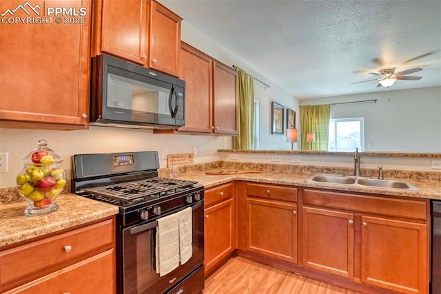 6676 Liberator Trl, Colorado Springs, CO 80925 - kitchen featuring black appliances, a sink, a ceiling fan, light wood-style flooring, and brown cabinets