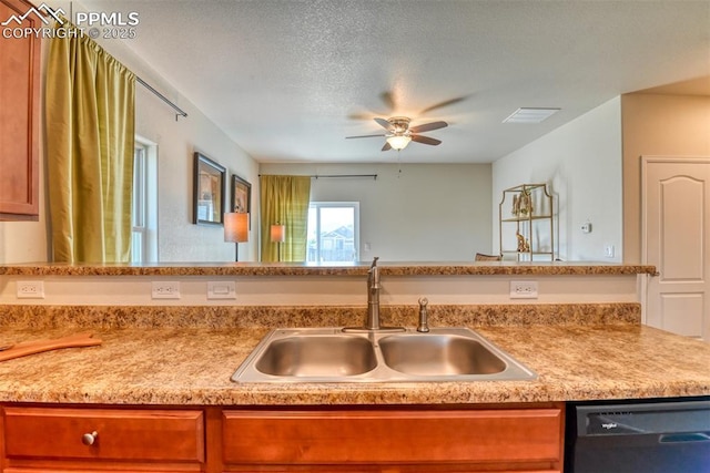 6676 Liberator Trl, Colorado Springs, CO 80925 - kitchen featuring a sink, dishwashing machine, ceiling fan, light countertops, and a textured ceiling