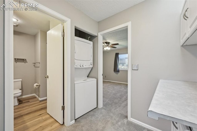 2013 Erin Loop, Colorado Springs, CO 80918 - laundry room featuring stacked washer and clothes dryer, a textured ceiling, a ceiling fan, and baseboards