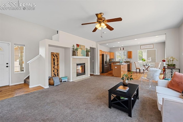 8370 Lupan Dr, Colorado Springs, CO 80951 - living room with stairway, a ceiling fan, light carpet, a tiled fireplace, and recessed lighting