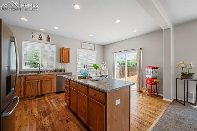 8370 Lupan Dr, Colorado Springs, CO 80951 - kitchen with stainless steel appliances, dark countertops, brown cabinets, recessed lighting, and a center island