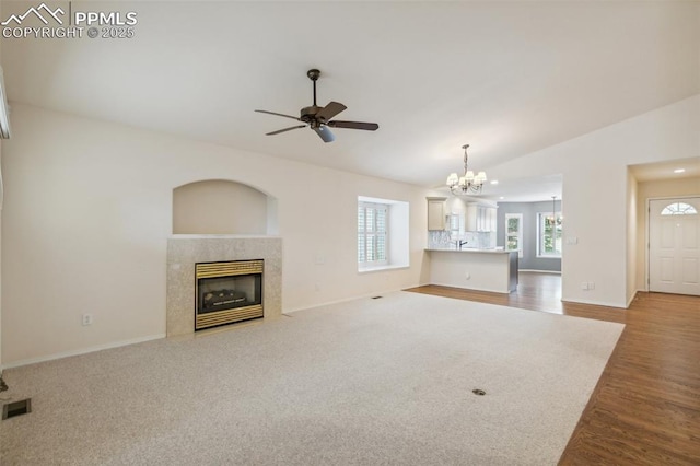 14115 Nichlas Ct, Colorado Springs, CO 80921 - unfurnished living room featuring a chandelier, vaulted ceiling, a premium fireplace, baseboards, and a ceiling fan