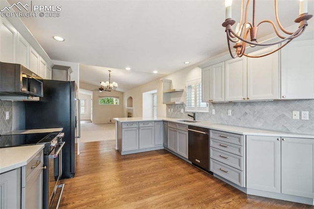 14115 Nichlas Ct, Colorado Springs, CO 80921 - kitchen with a chandelier, appliances with stainless steel finishes, a sink, a peninsula, and light countertops