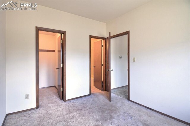 7770 N Topeka Ave, Cascade, CO 80809 - unfurnished bedroom with carpet flooring, a walk in closet, baseboards, and a closet