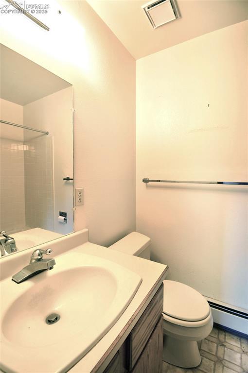 7770 N Topeka Ave, Cascade, CO 80809 - full bathroom with a baseboard radiator, toilet, vanity, and a shower
