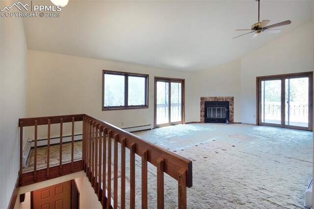 7770 N Topeka Ave, Cascade, CO 80809 - unfurnished living room featuring a baseboard heating unit, carpet, a glass covered fireplace, baseboards, and high vaulted ceiling