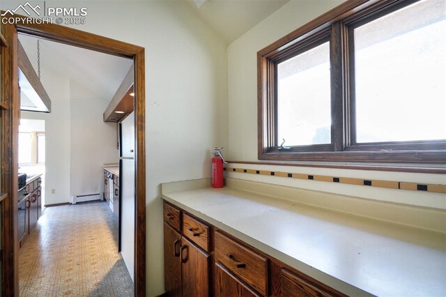 7770 N Topeka Ave, Cascade, CO 80809 - kitchen featuring vaulted ceiling, baseboard heating, light countertops, and light floors