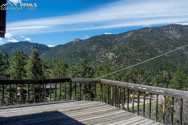 7770 N Topeka Ave, Cascade, CO 80809 - wooden terrace featuring a mountain view and a wooded view