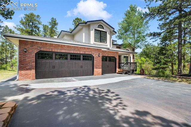 1240 Lone Scout Lookout, Monument, CO 80132 - view of front of home with brick siding, driveway, an attached garage, and stucco siding