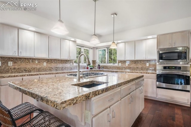 1240 Lone Scout Lookout, Monument, CO 80132 - kitchen with appliances with stainless steel finishes, a breakfast bar area, dark wood-style flooring, tasteful backsplash, and recessed lighting