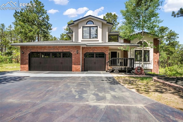 1240 Lone Scout Lookout, Monument, CO 80132 - view of front facade with brick siding, driveway, a garage, and stucco siding