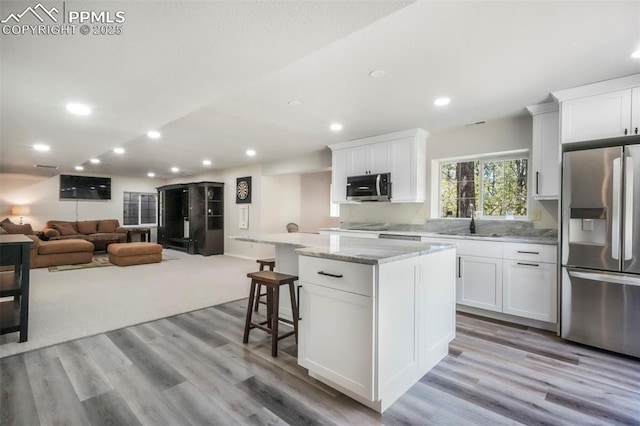 1240 Lone Scout Lookout, Monument, CO 80132 - kitchen with stainless steel appliances, a center island, white cabinetry, light wood-style floors, and recessed lighting