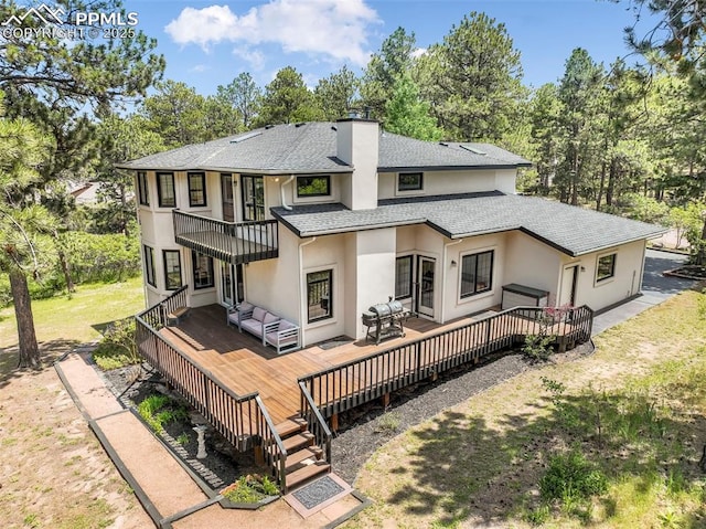 1240 Lone Scout Lookout, Monument, CO 80132 - rear view of house with a balcony, stucco siding, an outdoor hangout area, roof with shingles, and a wooden deck