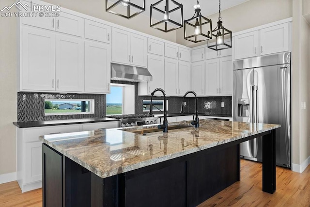 8545 Bailiff Dr, Peyton, CO 80831 - kitchen featuring stainless steel refrigerator with ice dispenser, under cabinet range hood, light wood finished floors, light stone counters, and backsplash