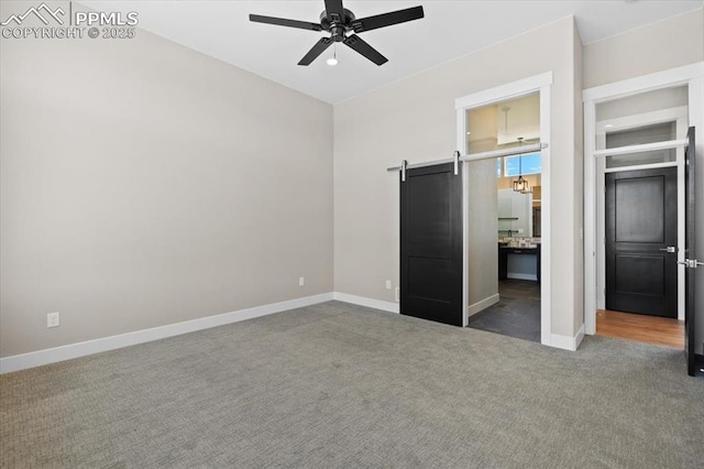 8545 Bailiff Dr, Peyton, CO 80831 - unfurnished bedroom with carpet floors, a barn door, and baseboards
