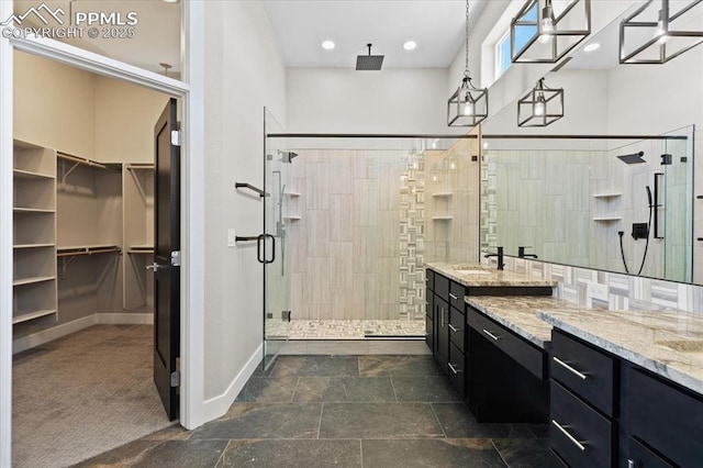 8545 Bailiff Dr, Peyton, CO 80831 - bathroom featuring a shower stall, vanity, a walk in closet, baseboards, and recessed lighting