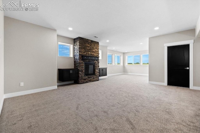 8545 Bailiff Dr, Peyton, CO 80831 - unfurnished living room featuring a stone fireplace, carpet floors, baseboards, and recessed lighting