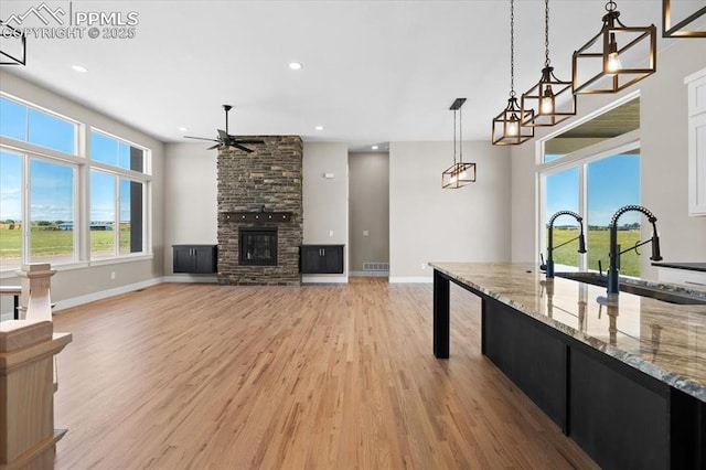 8545 Bailiff Dr, Peyton, CO 80831 - unfurnished living room with ceiling fan, light wood-type flooring, baseboards, a sink, and recessed lighting