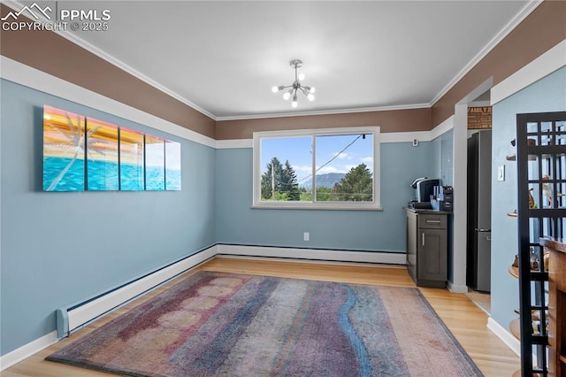 2206 Patrician Way, Colorado Springs, CO 80909 - unfurnished dining area with a baseboard heating unit, baseboard heating, light wood finished floors, a chandelier, and ornamental molding