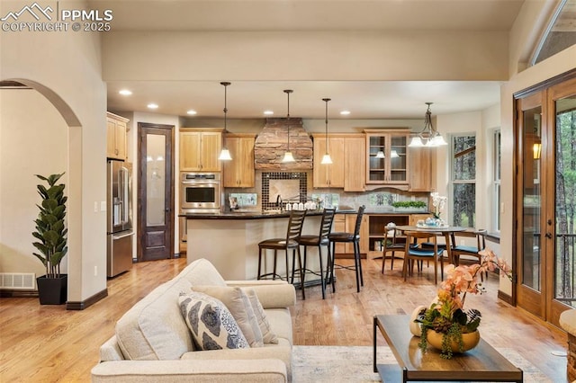 8395 Bar X Ter, Colorado Springs, CO 80908 - living room with light wood-style flooring, arched walkways, and recessed lighting