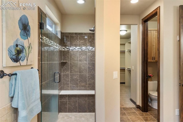 8395 Bar X Ter, Colorado Springs, CO 80908 - full bath with toilet, a shower stall, a walk in closet, tile patterned floors, and recessed lighting
