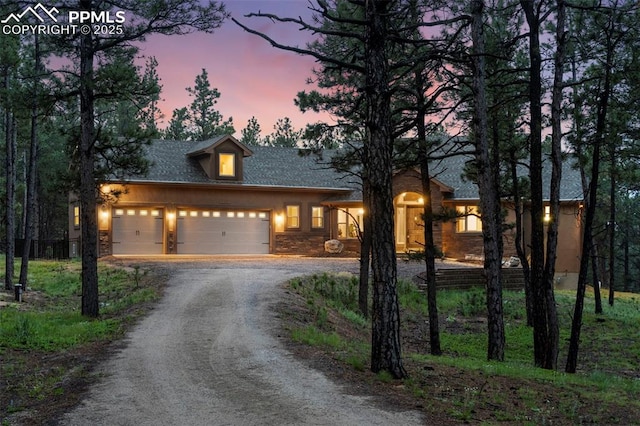 8395 Bar X Ter, Colorado Springs, CO 80908 - view of front of house with driveway, a garage, and stone siding