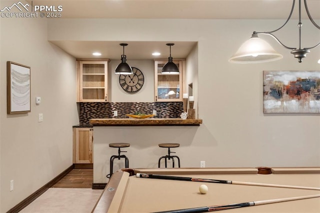 8395 Bar X Ter, Colorado Springs, CO 80908 - kitchen with backsplash, dark countertops, dark wood-style flooring, decorative light fixtures, and baseboards