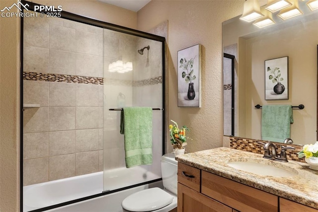 8395 Bar X Ter, Colorado Springs, CO 80908 - full bathroom with vanity, a textured wall, toilet, combined bath / shower with glass door, and backsplash