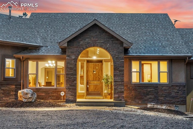 8395 Bar X Ter, Colorado Springs, CO 80908 - doorway to property featuring stone siding and roof with shingles