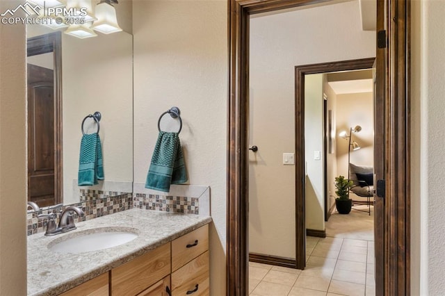 8395 Bar X Ter, Colorado Springs, CO 80908 - bathroom with tile patterned flooring, vanity, decorative backsplash, and baseboards