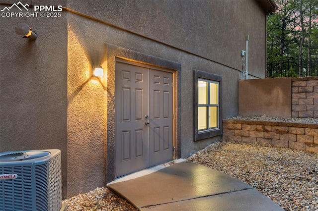 8395 Bar X Ter, Colorado Springs, CO 80908 - property entrance with stucco siding and central AC