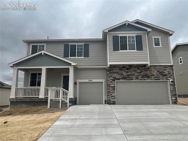 10316 Hartwood Dr, Peyton, CO 80831 - view of front of property with a garage, concrete driveway, a porch, and stone siding