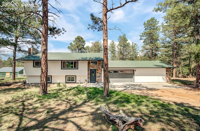 4580 Creek View Rd, Colorado Springs, CO 80908 - view of front of property featuring concrete driveway, stucco siding, a garage, a chimney, and stone siding
