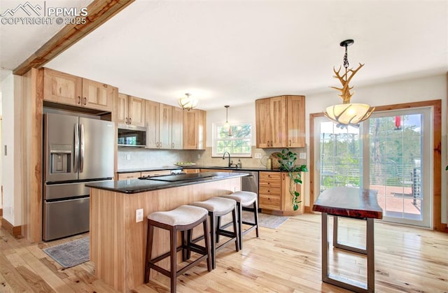 4580 Creek View Rd, Colorado Springs, CO 80908 - kitchen with stainless steel appliances, dark countertops, light wood-style flooring, tasteful backsplash, and a sink
