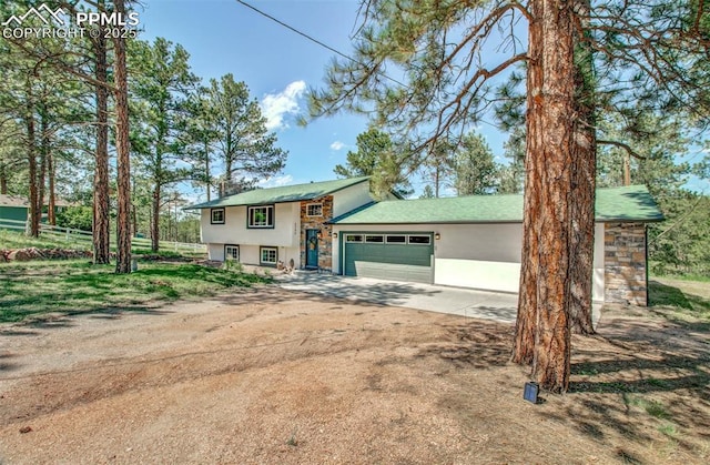 4580 Creek View Rd, Colorado Springs, CO 80908 - tri-level home with a garage, concrete driveway, and stucco siding